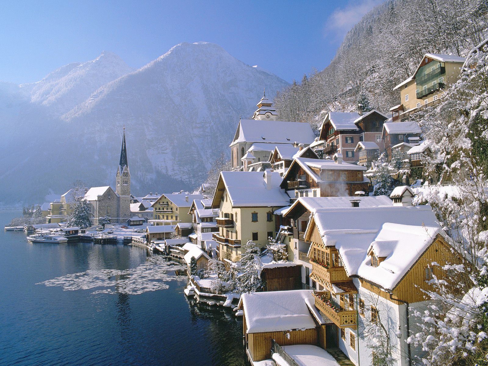 Vista aérea de uma vila na encosta de uma montanha com um lago e uma igreja. (hallstatt, inverno, aldeia montanhosa, montanha, cadeia de montanhas)