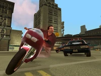 Escena de persecución llena de acción en un paisaje urbano vibrante de "Grand Theft Auto: Vice City Stories", donde un motociclista evade a la policía en un entorno clásico.