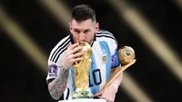 Lionel Messi kisses the FIFA World Cup trophy in celebration.