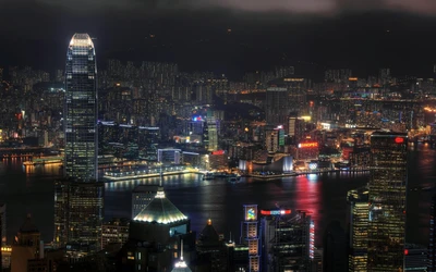 Horizonte iluminado de Hong Kong à noite com reflexos na água