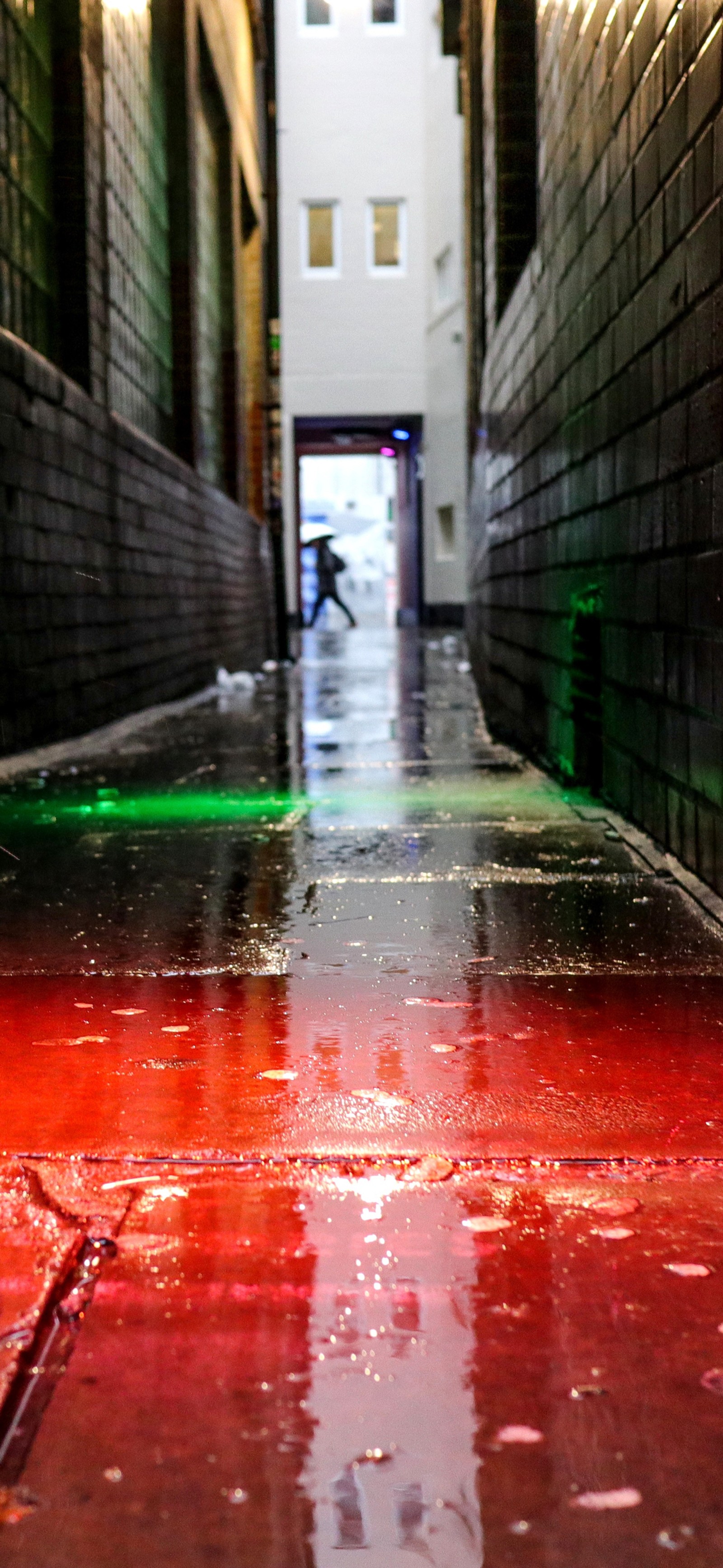 Hay una sustancia roja en el suelo de un callejón estrecho (ios, manzanas, lluvia, agua, colorido)