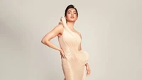 Elegant Indian actress in a stunning, sculptural gown, showcasing contemporary fashion.