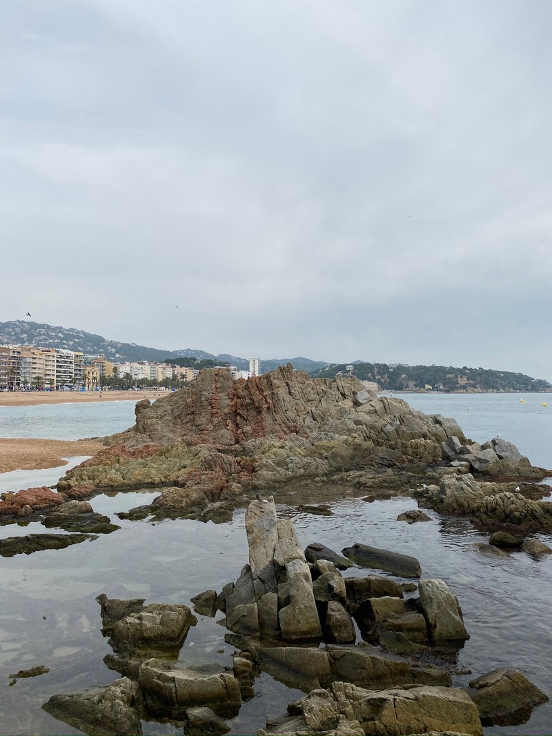 В воде у пляжа лежит маленький камень (море, вода, скала, берег, коренная порода)