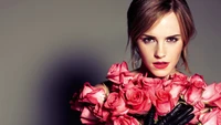 Emma Watson sosteniendo un ramo de rosas rosas, exudando elegancia y confianza.