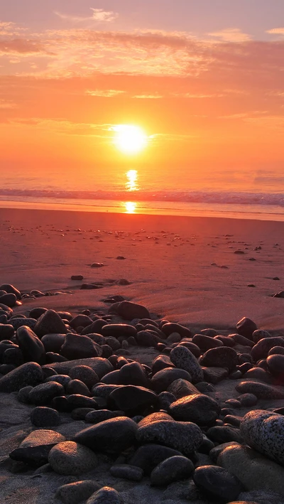 Pôr do sol vibrante sobre uma praia rochosa