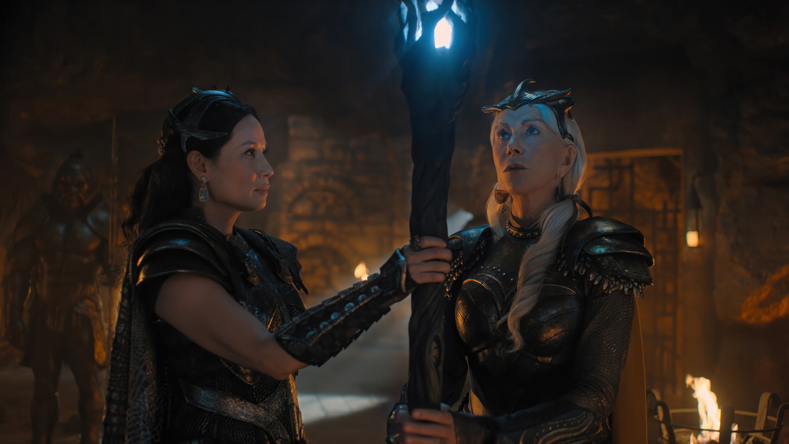 Dos mujeres en armadura sosteniendo antorchas en una cueva (shazam la furia de los dioses, shazam fury of gods, película, 2023, shazam 2)