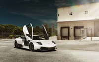 White Lamborghini Murciélago with scissor doors open, parked in an industrial setting.