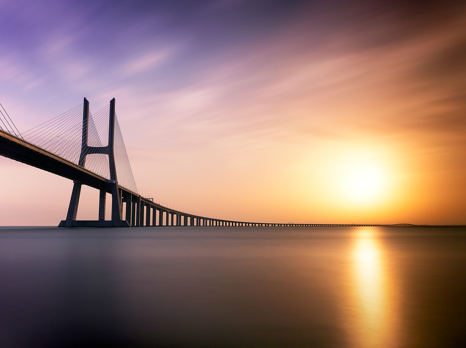 Воздушный вид на мост над водоемом на закате (vasco da gama bridge, лиссабон, lisbon, португалия, tagus river)