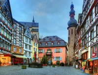 Encantadora arquitectura medieval en el corazón de Mosela, con una pintoresca plaza con fachadas coloridas y una torre histórica.