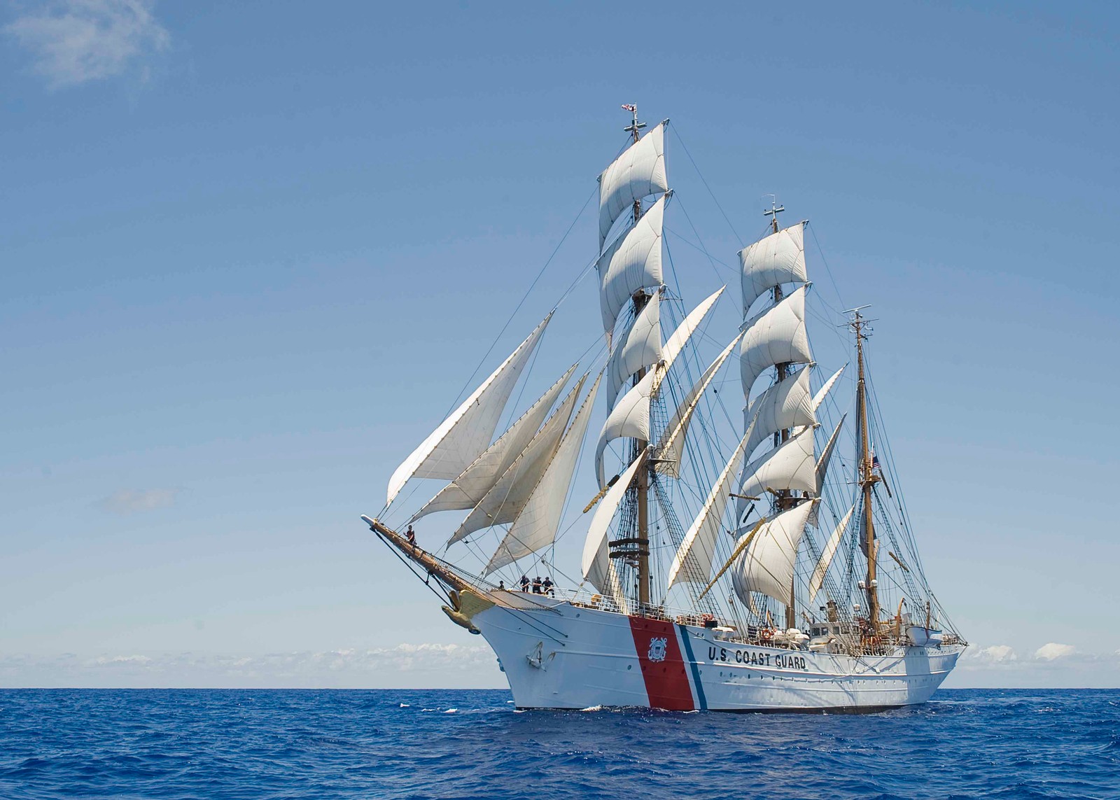 Vue d'un voilier avec des voiles blanches dans l'océan ouvert avec un ciel bleu (navire, voilier, barquentine, grand navire, bateau)