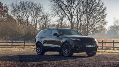 SUV preto Land Rover com rodas de liga leve estacionado em um ambiente externo nebuloso.