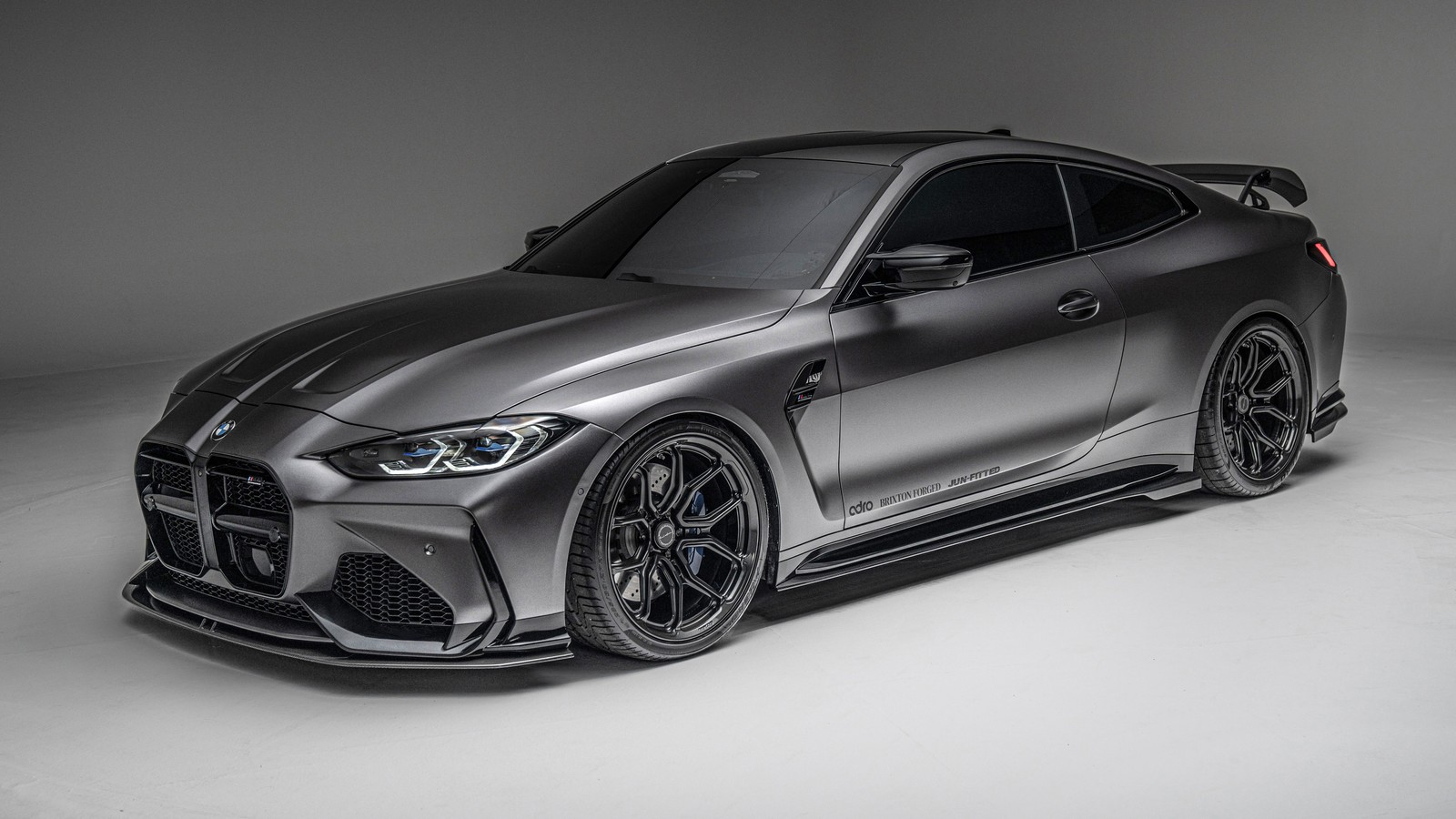 Un primer plano de un coche en un estudio con un fondo gris (bmw m4 coupé, bmw m4 coupe, sedán de rendimiento, 5k, 8k)