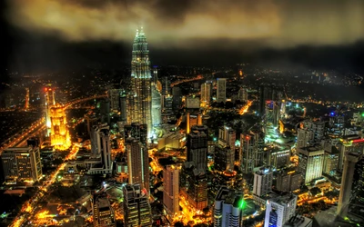 Deslumbrante horizonte noturno de Kuala Lumpur, apresentando as icônicas Torres Petronas e luzes vibrantes da cidade iluminando a movimentada paisagem urbana.