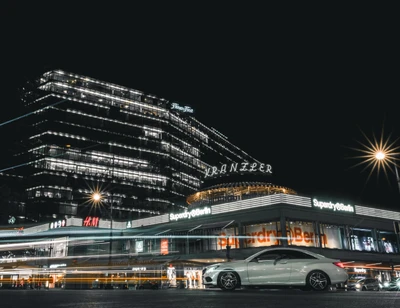 Lebendige städtische Nachtlandschaft: moderne Architektur und Auto in Berlin