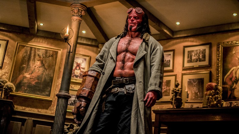 Хеллбой стоит в комнате с лампой и картинами на стене (хеллбой, hellboy, хеллбой 2019, hellboy 2019, фильм)