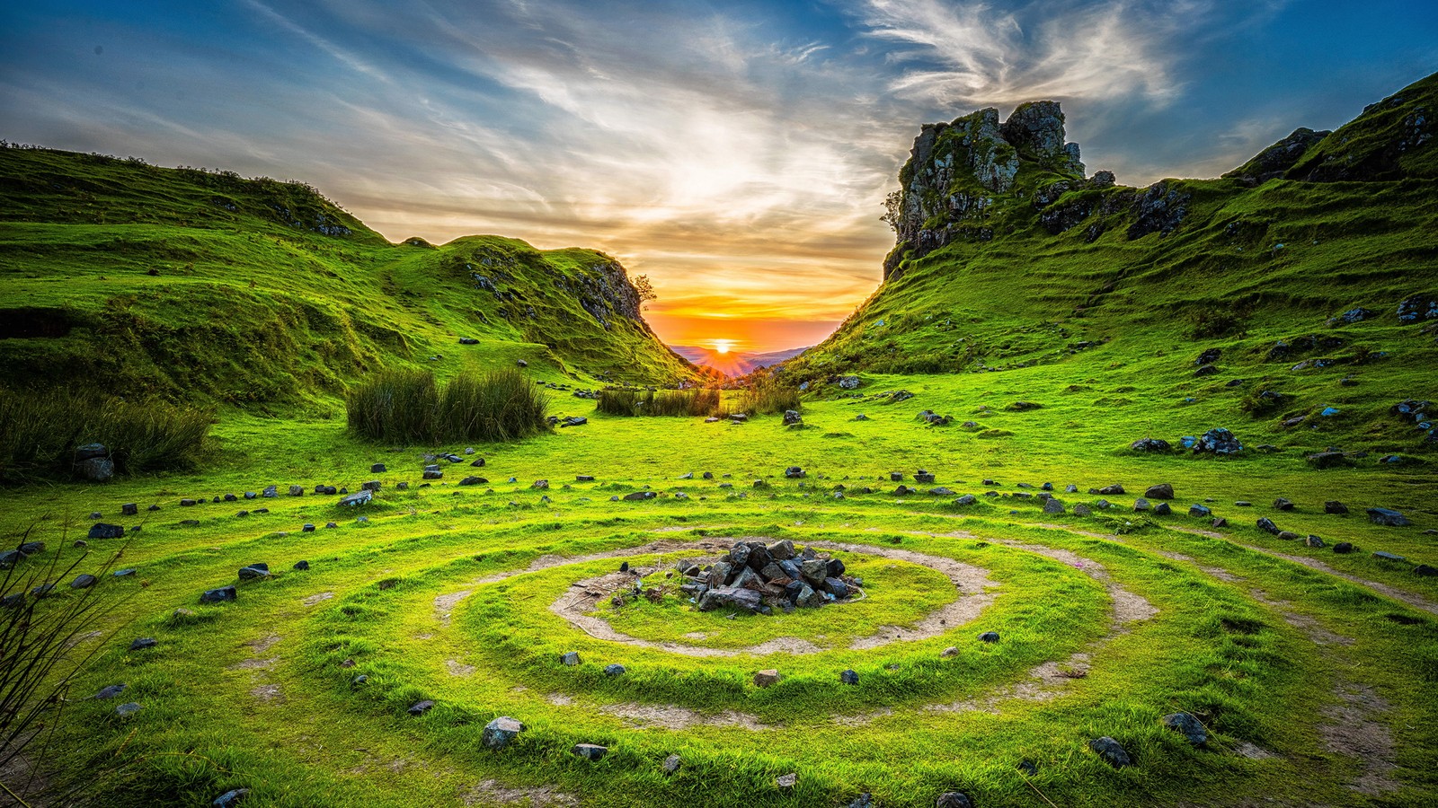 Um campo verde com uma espiral no meio (natureza, grama, paisagem, terras altas, pradaria)