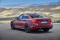 2018 BMW M5 - um sedã esportivo poderoso e luxuoso com tração nas quatro rodas e rodas de liga leve impressionantes, contra um cenário montanhoso pitoresco.