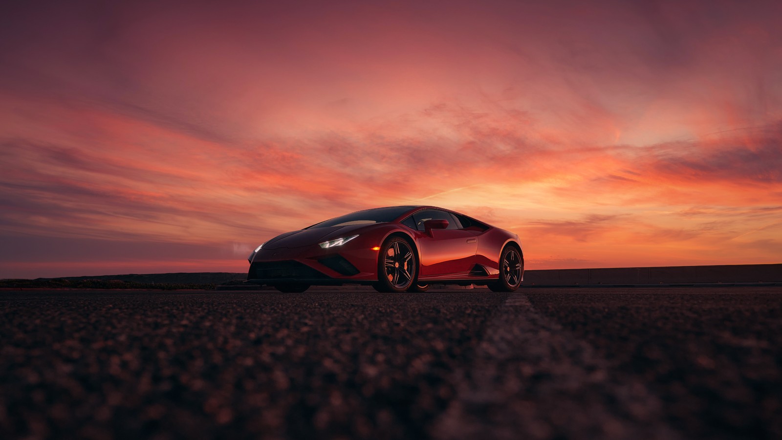 Ein roter sportwagen, der bei sonnenuntergang auf der straße parkt (lamborghini huracan evo rwd, sonnenuntergang, 5k, autos, 4k hintergrund)