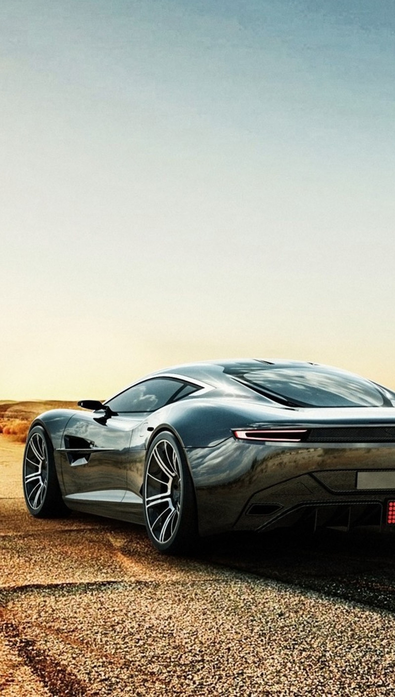 A close up of a car parked on a dirt road (aston martin, car, machine)