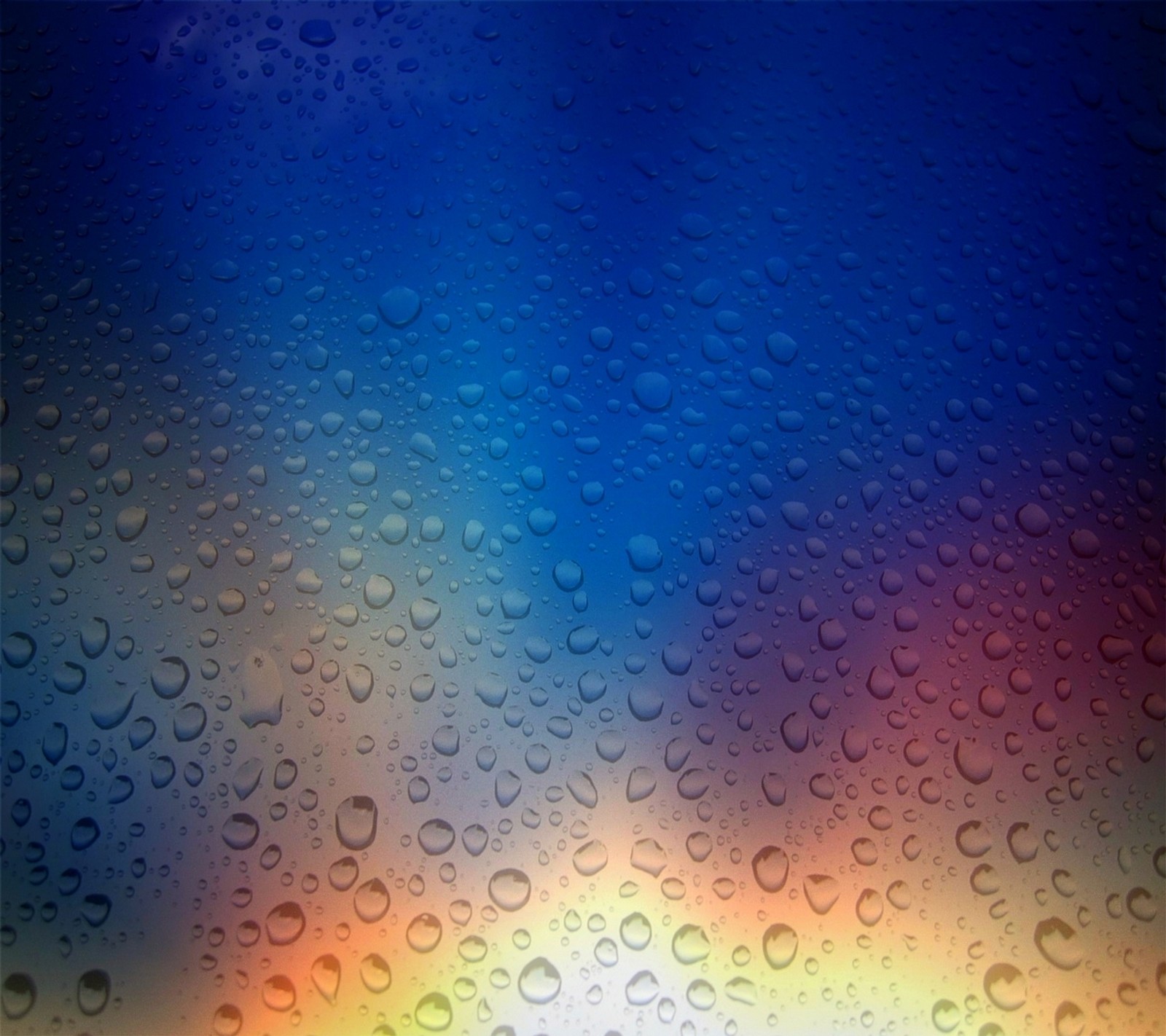 A close up of a rain covered window with water droplets (abstract, blur, colors, drops, glass)