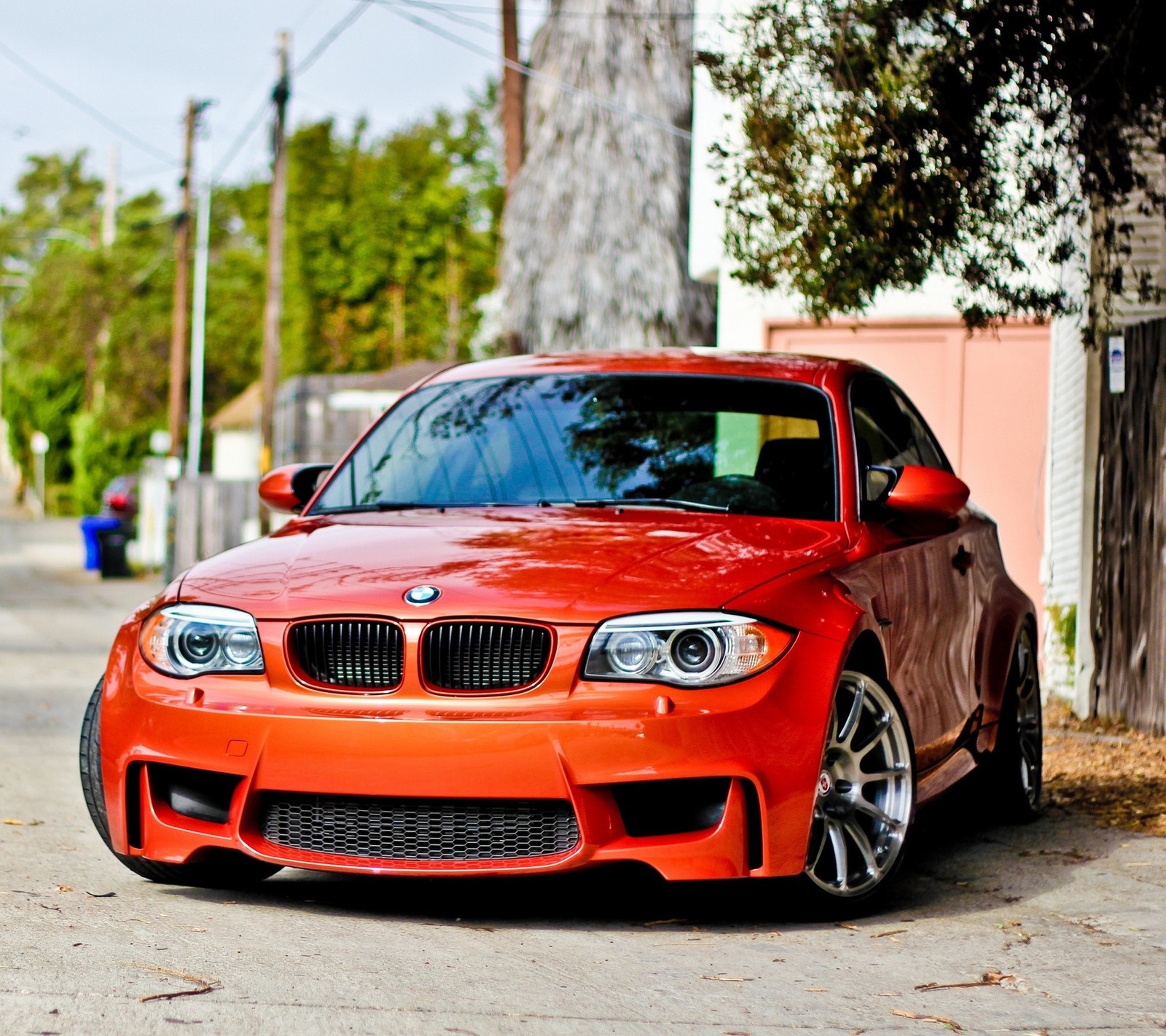 Ein orangefarbener bmw, der am straßenrand parkt (bmw, auto, orange)