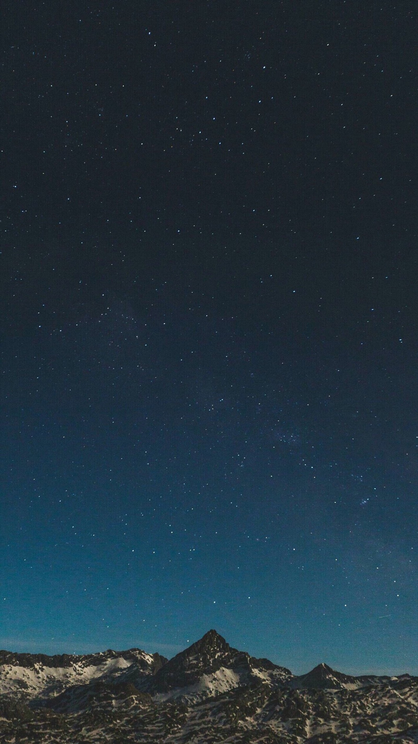 Starry sky over a mountain range with a snowboarder in the foreground (night, other)