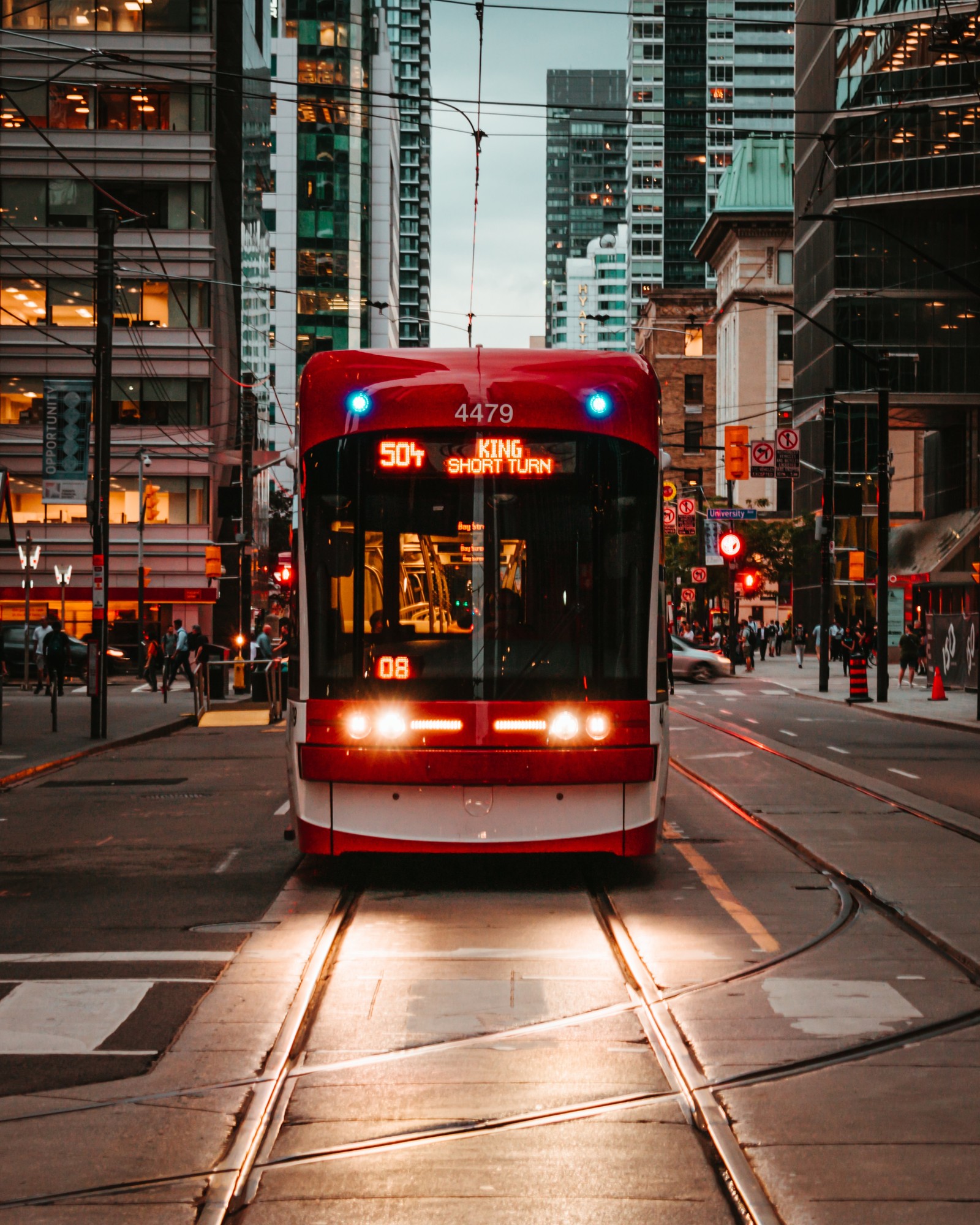 Ein roter und weißer zug auf schienen in der stadt bei nacht. (transport, metropole, stadtgebiet, öffentliche verkehrsmittel, bus)