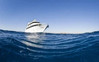 Luxury yacht sailing on calm blue waters under a clear sky.