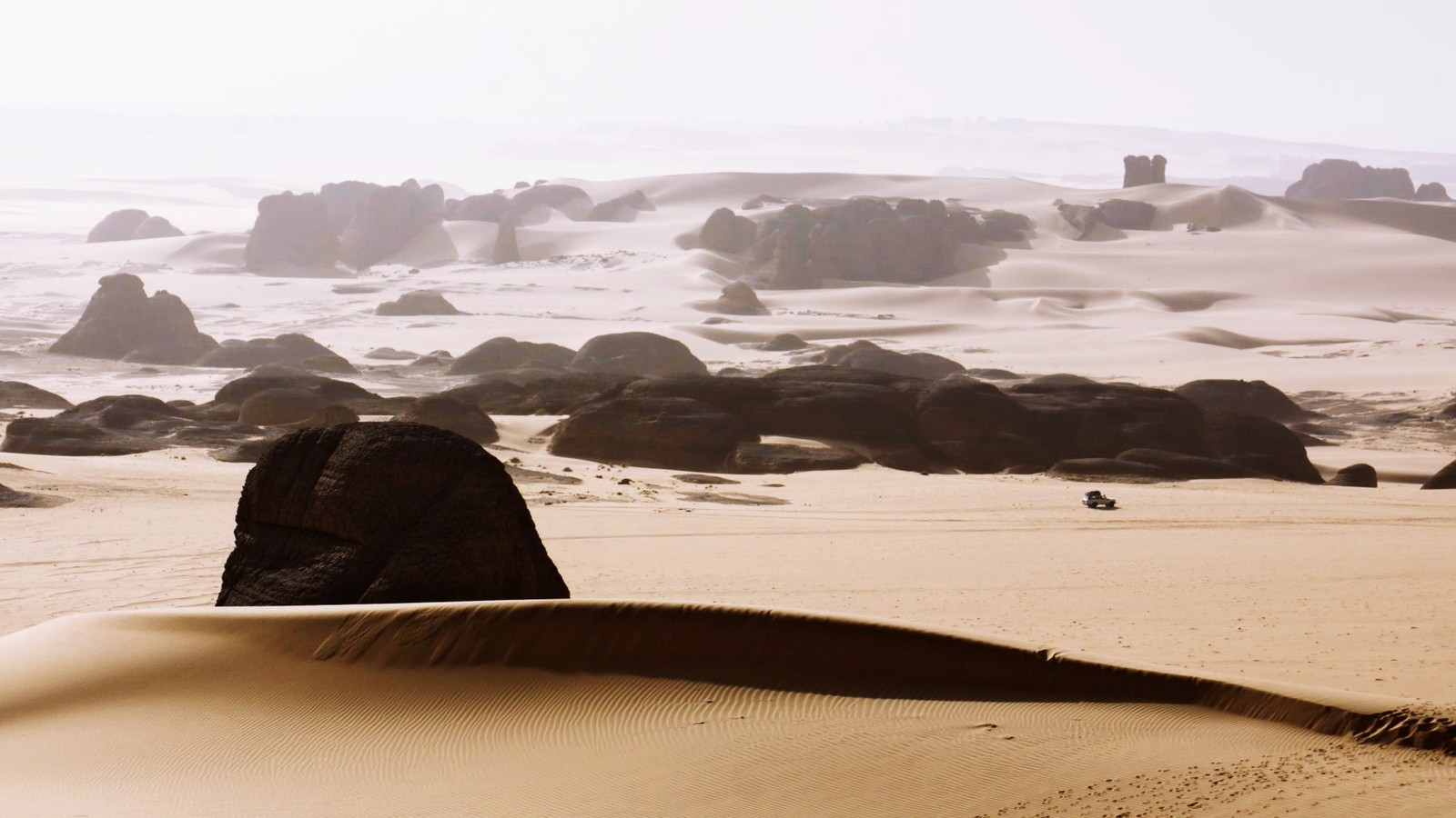 Hay una gran roca en medio de un desierto. (arena, desierto, costa, mar, orilla)