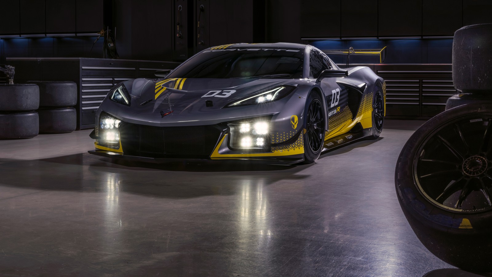 A close up of a car in a garage with a tire (chevrolet corvette z06 gt3 r, 5k, race cars, cars, 4k wallpaper)