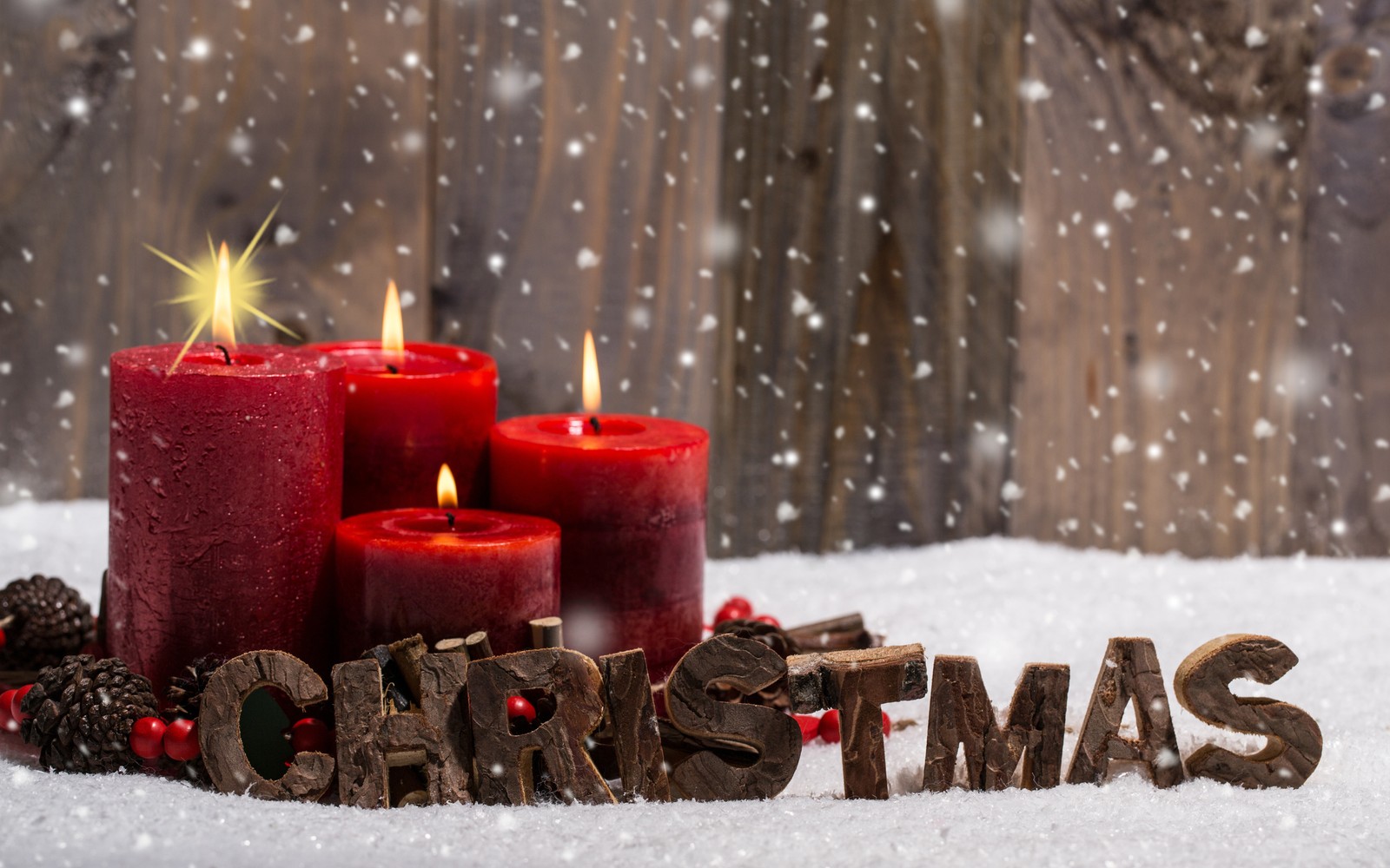 A close up of three red candles with christmas decorations in the snow (christmas day, candle, christmas decoration, christmas tree, holiday)