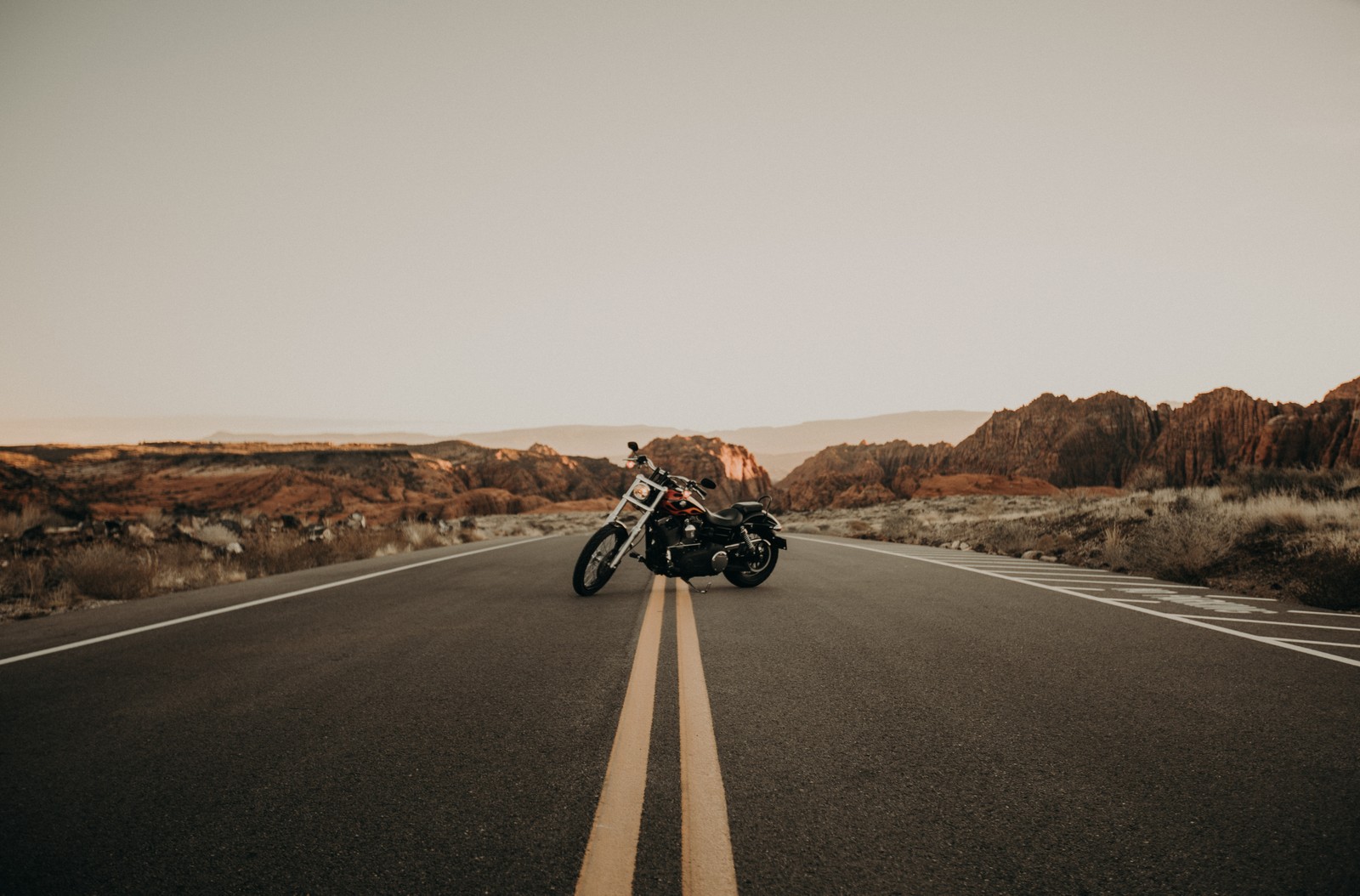 Arafed motorcycle parked on the side of a road in the desert (motorcycle, road, bicycle, asphalt, highway)