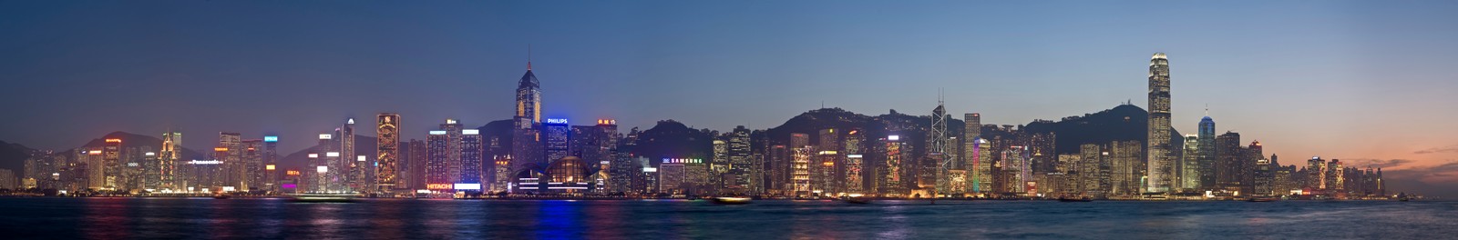 Uma vista do horizonte da cidade à noite com um barco na água (victoria harbour, cidade, linha do horizonte, paisagem urbana, metrópole)