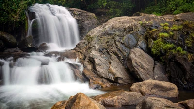 Cascata serena caindo sobre um afloramento rochoso em uma reserva natural