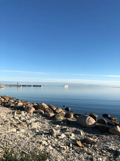 Línea de costa tranquila con aguas claras y costa rocosa