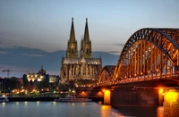 Catedral iluminada e ponte sobre o rio à noite