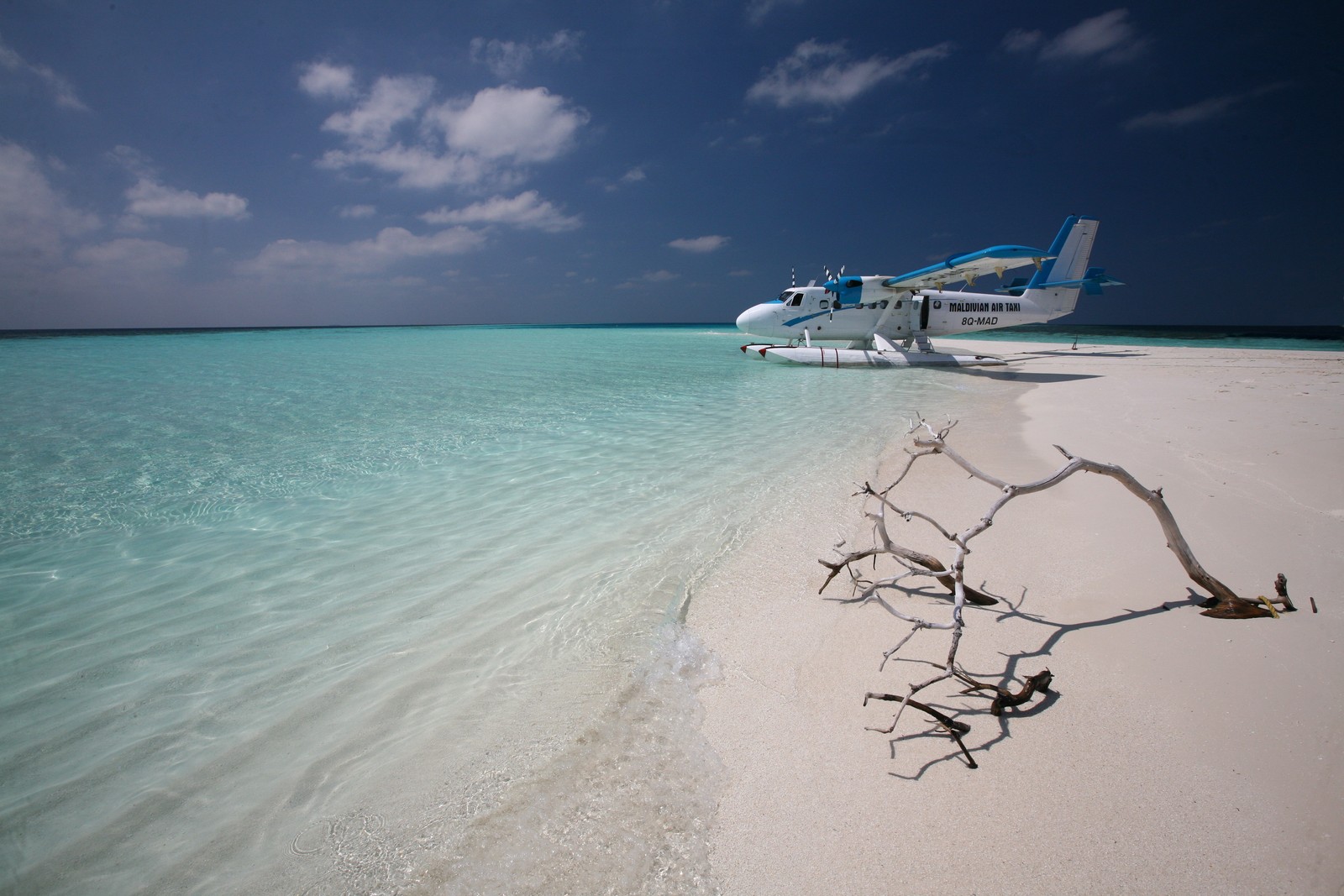 There is a plane that is sitting on the beach by the water (sea, caribbean, beach, vacation, ocean)