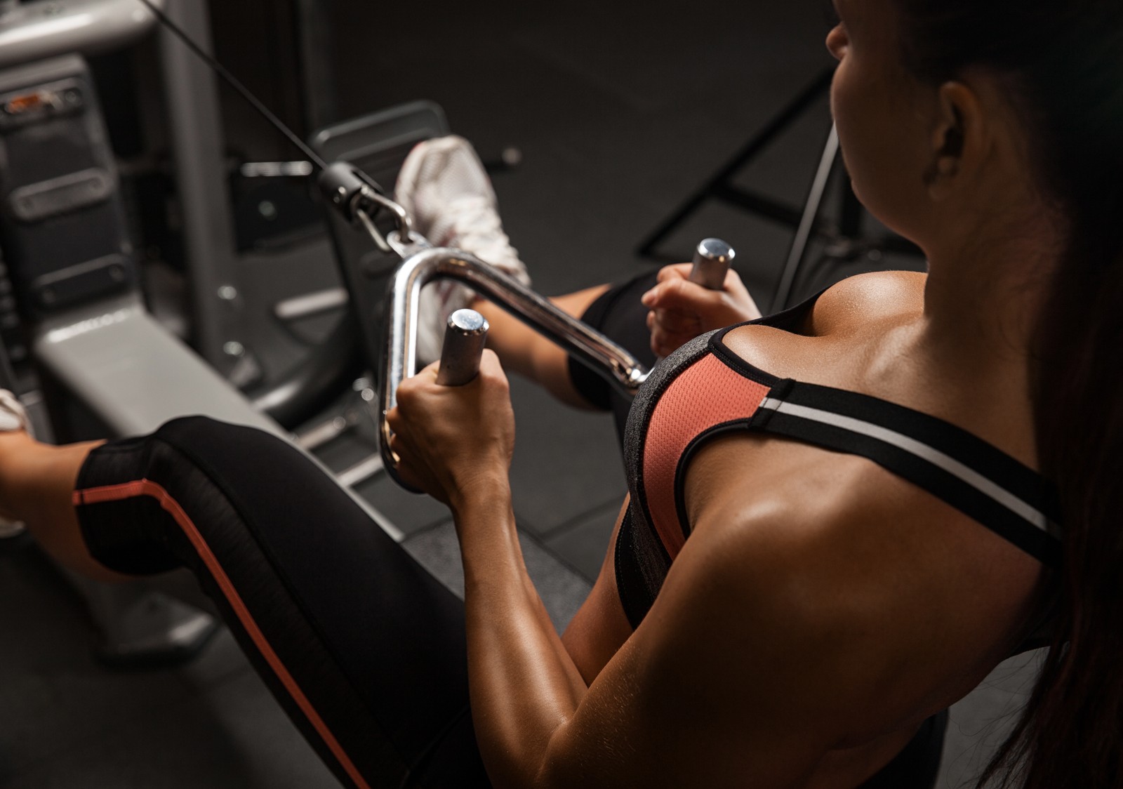 Mujer artística usando una máquina en el gimnasio (gimnasio, aptitud física, centro de fitness, máquina de ejercicio, músculo)