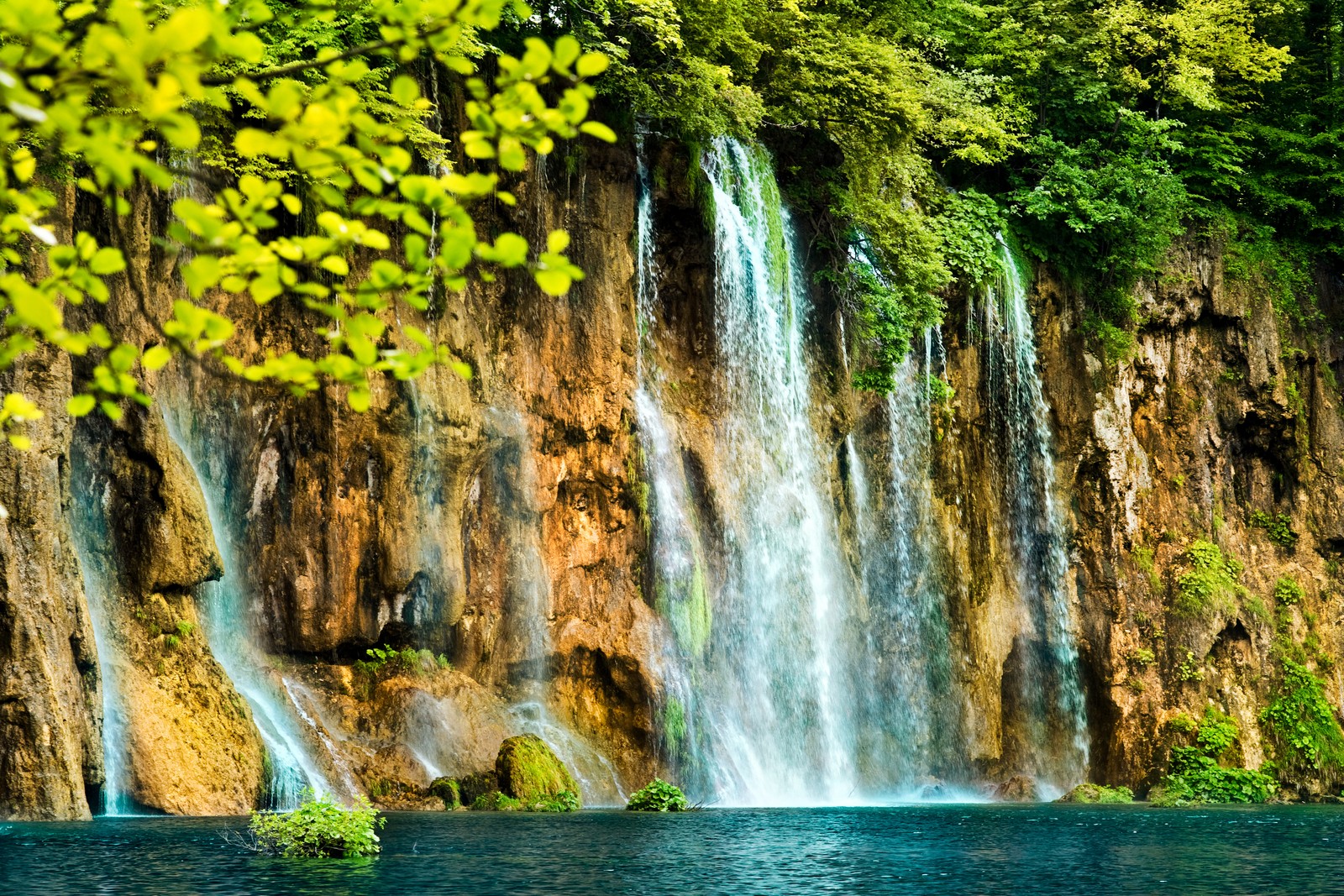 A close up of a waterfall with a boat in the water (nature, waterfall, body of water, water resources, water)