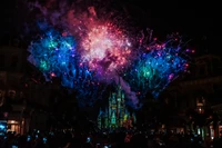 Fogos de artifício vibrantes iluminam o céu noturno sobre um castelo durante uma celebração festiva