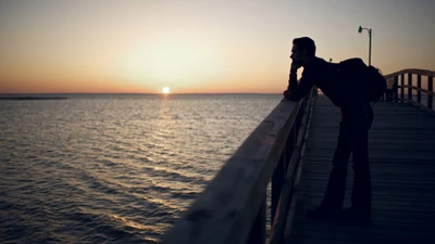 Nachdenken über den Sonnenuntergang über einem ruhigen Meer