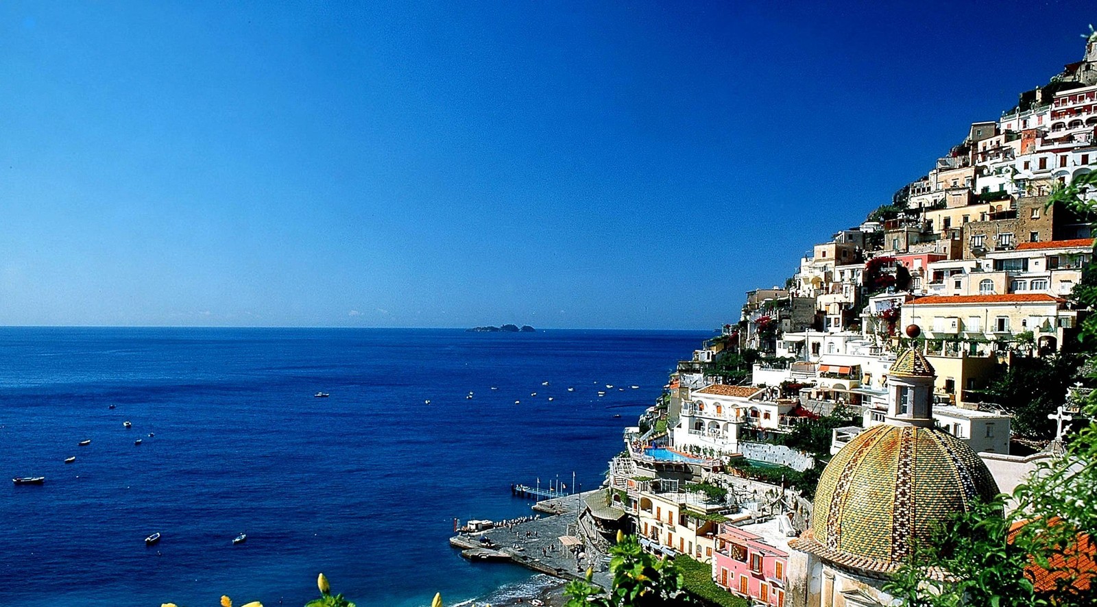 Uma vista de uma cidade em um penhasco com vista para o oceano (positano, sorrento, mar, costa, turismo)