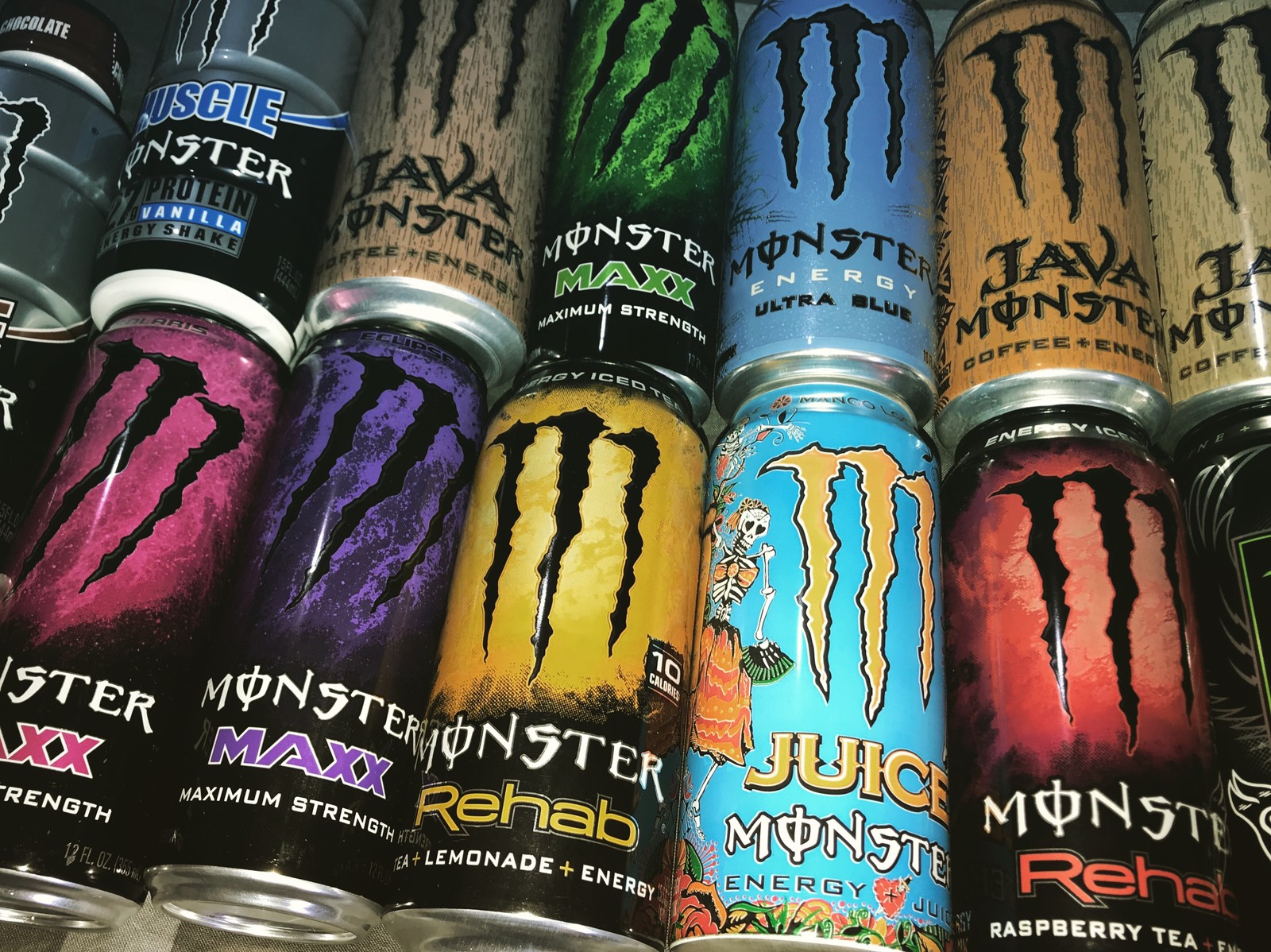 Um close em um grupo de latas de bebidas energéticas (monstro, energia, energydrink, garrafas, bar)