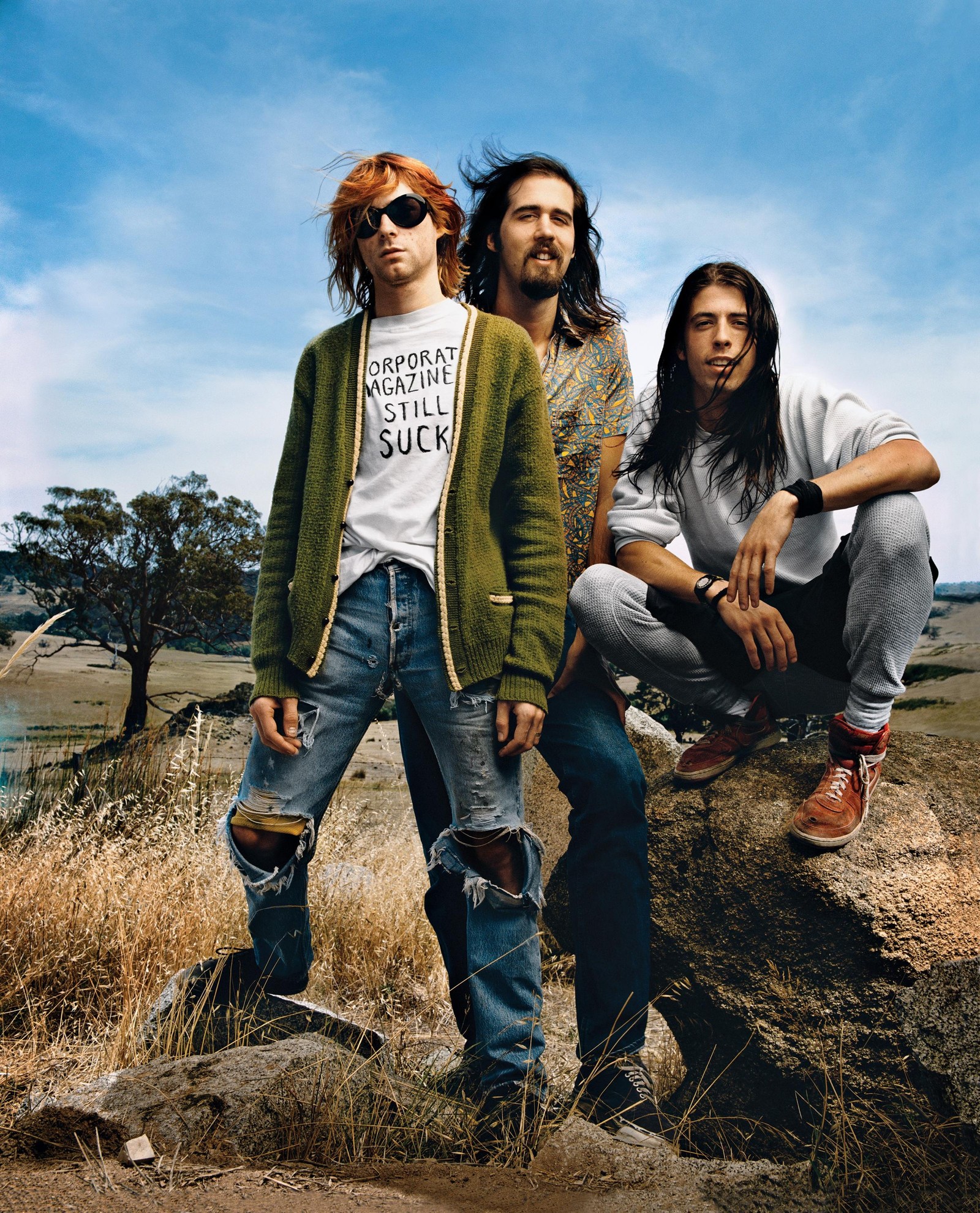 Une image de trois hommes assis sur une roche dans un champ (nirvana, roche, magazine, jeans, denim)