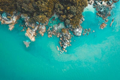 Eaux turquoise sur un récif corallien vierge et un paysage côtier rocheux