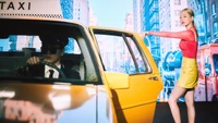 Sunny from Girls' Generation poses confidently beside a bright yellow taxi in a vibrant city backdrop, embodying the energetic spirit of K-pop.