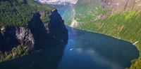 Atemberaubende Luftaufnahme der majestätischen Klippen und ruhigen Gewässer des Geirangerfjords