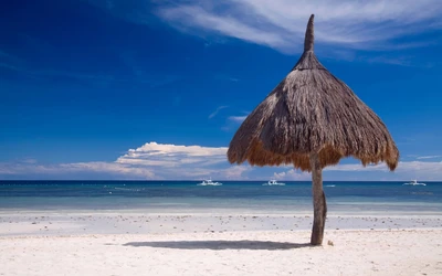 Idyllic Philippine Beach with Thatched Umbrella and Clear Blue Ocean