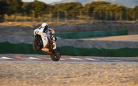 Pilote de KTM Supermoto effectuant un wheeling sur la piste de course