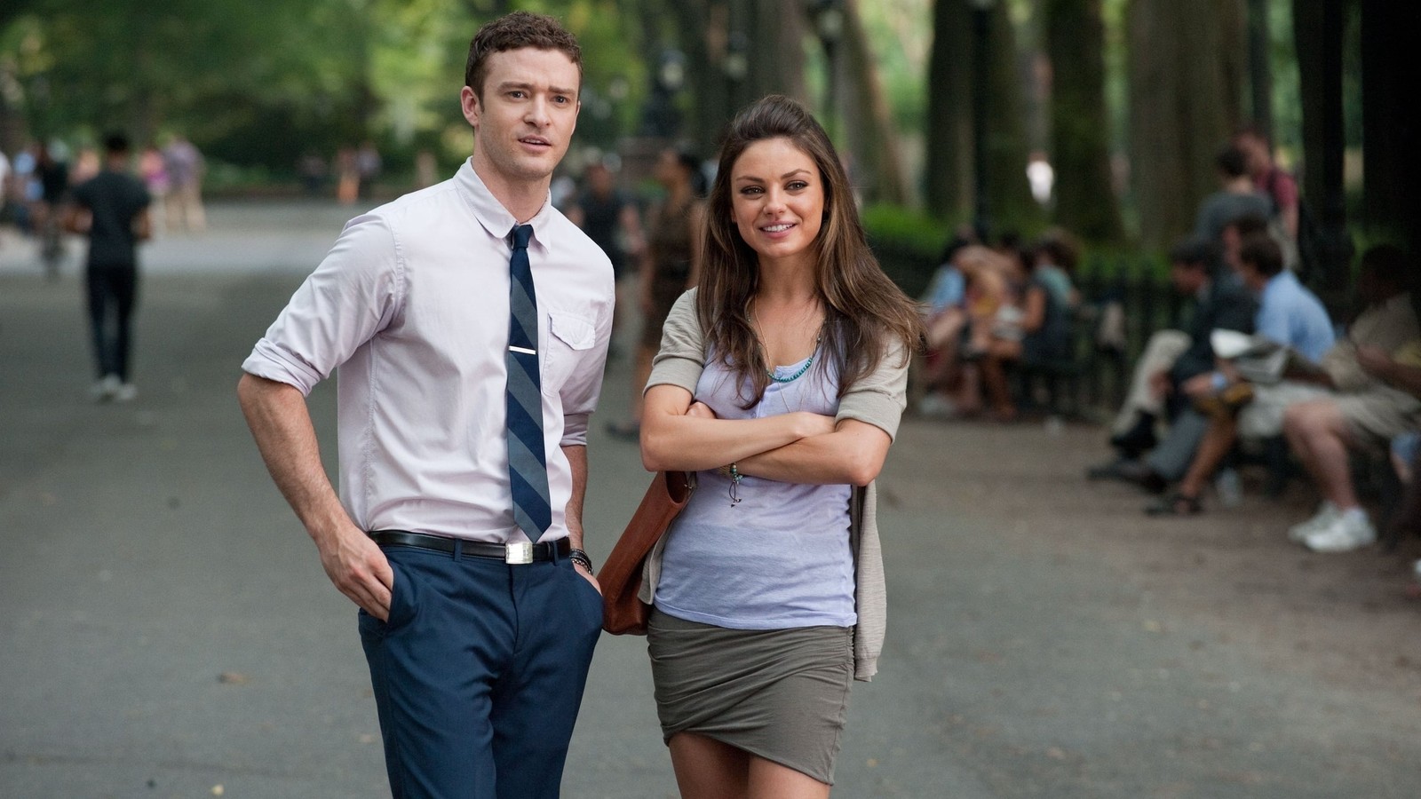 Hay dos personas de pie una al lado de la otra en un parque (mila kunis, foto instantánea, interacción, película, calle)